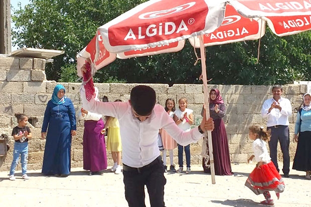 Kavurucu sıcak altında dev şemsiye ile halay