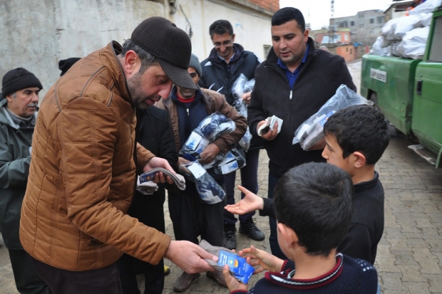 Suriyelilere çorap ve odun dağıtıldı